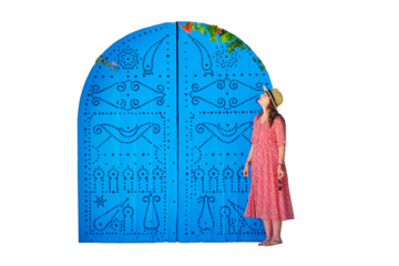 A young woman next to a house wreathed in vines with flowers in Sidi Bou Said, isolated on a white background
