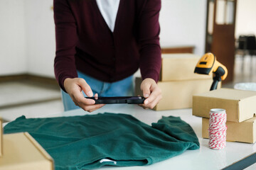 Fototapeta premium Female owner taking pictures of online product.