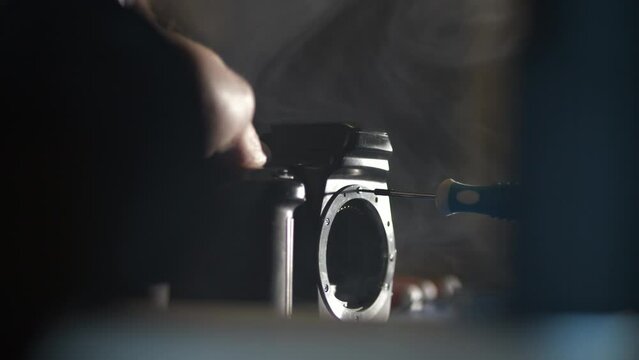 Person repair camera at his workshop, cinematic view