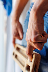 strong male rock climber's hand holds board for finger strength training with one finger. climbing workout at home. fingerboard and hangboard.