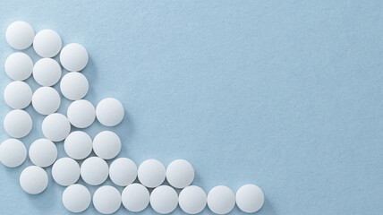 White pills or capsules lies in rows on blue background