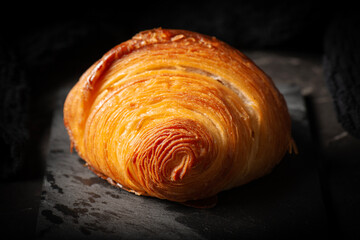 Delicious golden brown baked crispy and flaky plain buttery croissant.