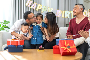 Portrait of happy love asian big family father and mother with asian baby and little girl happy birthday, party, celebration, cake, surprise, grandfather with grandmother smiling together.Family party