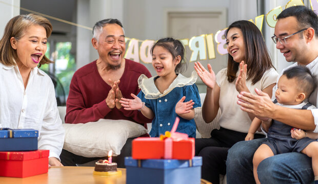 Portrait of happy love asian big family father and mother with asian baby and little girl happy birthday, party, celebration, cake, surprise, grandfather with grandmother smiling together.Family party