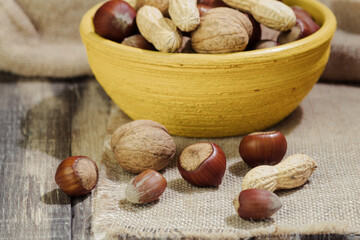 A mix of nuts in a shell, in a clay plate
