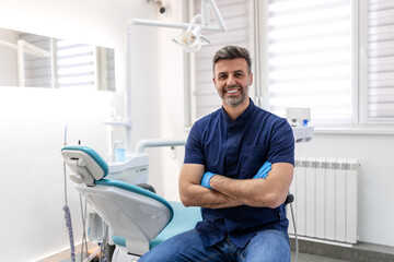 Dentist man smiling while standing in dental clinic. Portrait of confident a young dentist working...