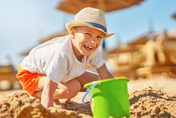Image of a young boy playing with sand on the beach