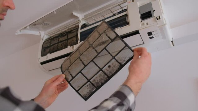 Air conditioner filter dusty. Preparation for maintenance and cleaning.
