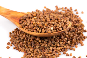 Uncooked buckwheat on wooden spoon