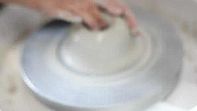 Female potter works with potter weel, craftsman hands close up. Hands of potter making clay pot. High quality 4k footage