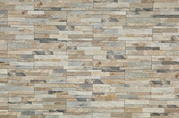 Stoneware paneling wall with stone effect. Colors are shade of gray ,brown and white. Exterior home decor, background and texture.