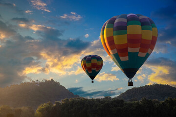 Hot air balloon above mountasin view at sunset