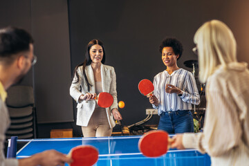 Young people playing table tennis in the office at work - obrazy, fototapety, plakaty