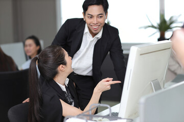 Attractive professional asian female employee worker working, using computer presentation and brainstorming ideas with coworker going over on new project together at office workplace