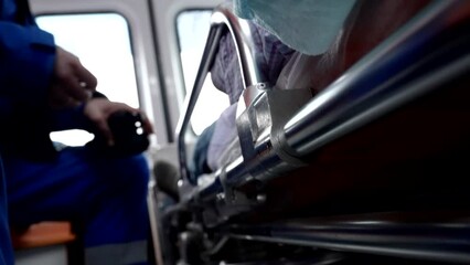 health professional transporting sick old man in ambulance car, doctor and unconscious male patient