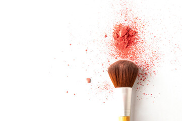 Make up brush with a smashed natural blush powder on a white background. Make up swatch and tool