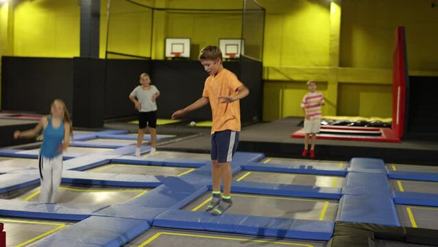 Happy boy jumping on trampoline park in sport center