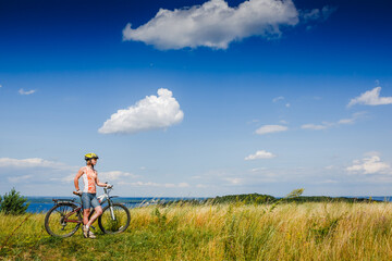 Fototapeta premium Mountain biking - woman with bike enjoy summer vacation