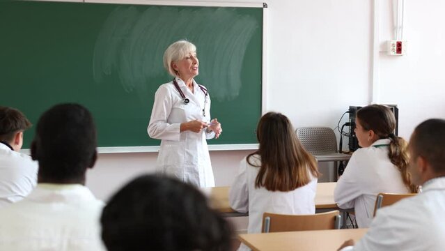Mature female medicine teacher prompting adult student while studying in university class. High quality 4k footage