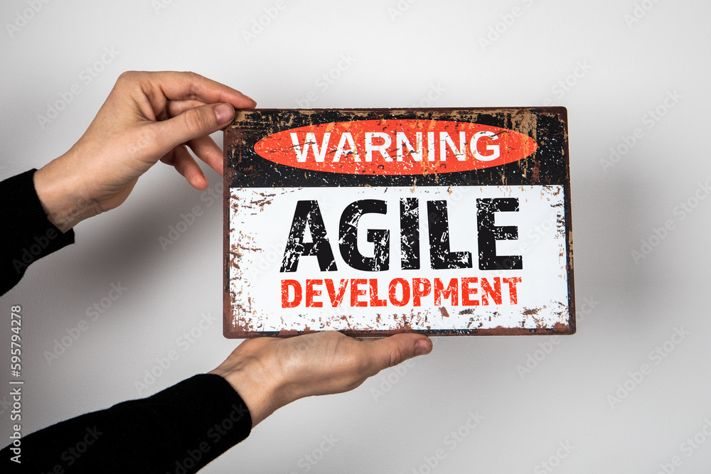 Sticker agile development. warning sign with text in the hands of a woman