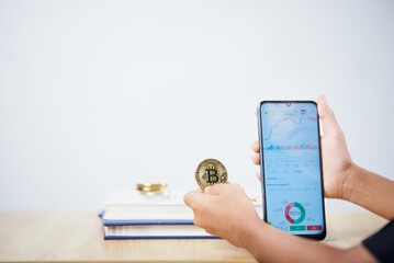 Hands holding gold Cryptocurrencies coin and smartphone with white background