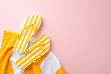 Minimal trendy vacation essentials concept. Top view flat lay of yellow striped flip-flops, towel...