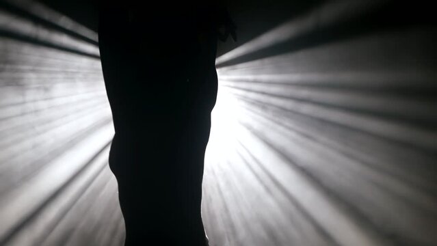 gorgeous woman dancing in dark studio against bright soffit, silhouette of beautiful slender body