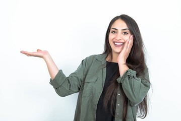 Crazy young brunette woman wearing casual clothes over white studio background advising discount prices hold open palm new product
