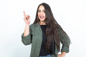 young brunette woman wearing casual clothes over white studio background holding finger up having idea and posing