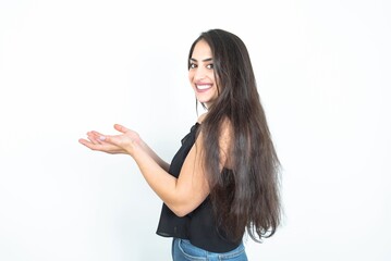 young brunette woman wearing casual clothes over white studio background pointing aside with hands...