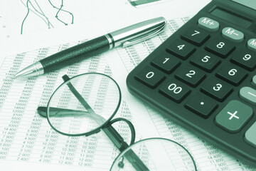 Data analytics concept. Financial documents, glasses, pen and calculator close-up.