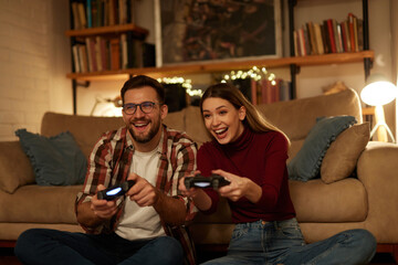 Young couple having fun at home playing video games