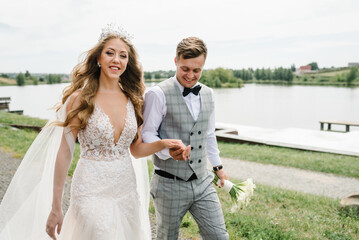 Naklejka premium Amazing smiling wedding couple. Pretty bride and stylish groom. Romantic wedding moment.