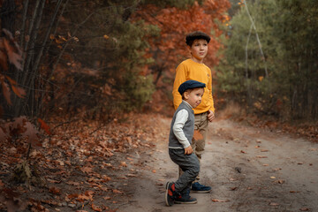 Fashionably dressed children posing in the forest. Retro style, children's autumn fashion.