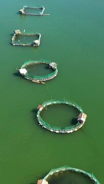 Aerial view of Fish farm with cages for fish and shrimp. Fish ponds for bangus, milkfish. Farming aquaculture or pisciculture practices. Philippines, Luzon.