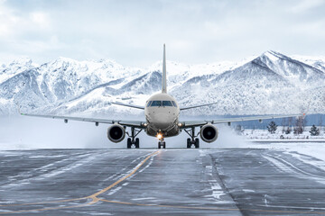 Front view of the passenger airplane taxiing on taxiway on the background of high picturesque...