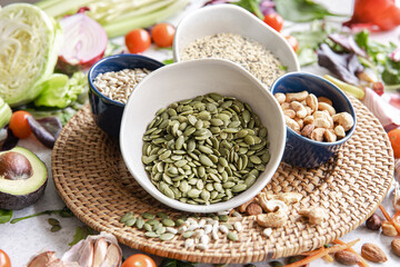Close-up, a bowl of pumpkin seeds and other healthy foods on the kitchen table.