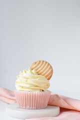 Pink cupcakes with tall american buttercream swirl and cookie garnish, cupcakes in pink liners with a tall vanilla buttercream and a cookie, birthday cupcakes on a white background