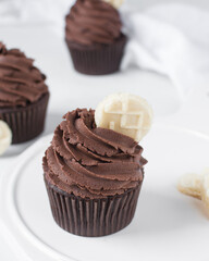Chocolate cupcake with dark chocolate buttercream, double chocolate cupcakes with american buttercream, tall swirl frosting on a cupcake with a wafer