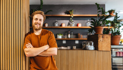 Portrait of a male small business owner standing in front of his coffee shop