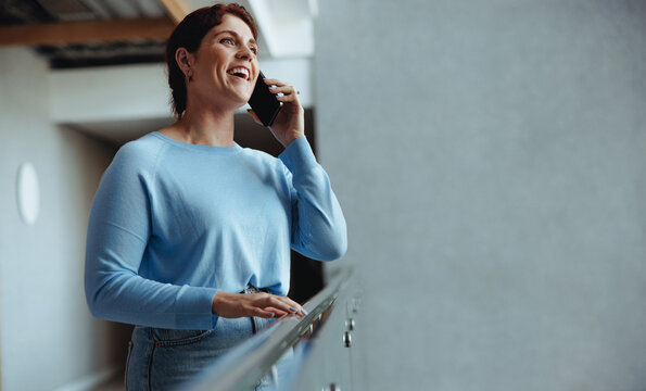 Business communications: Professional woman answering a phone call in an office