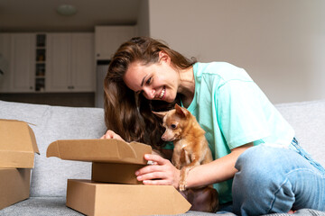Woman and her lap dog together unboxing postal parcels. - obrazy, fototapety, plakaty