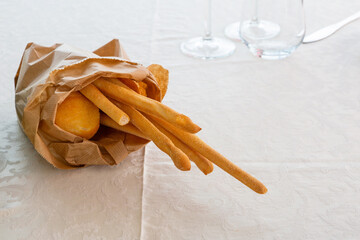 Grissini or bread sticks on white tablecloth - 595825451