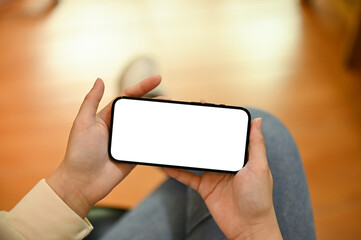 A woman watching videos or online viral clips on her smartphone in her living room