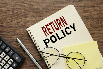 black calculator and notepad with spring. text Return policy. online store orders, company policies...