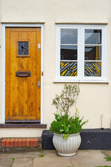 Fototapeta na wymiar English village front door window and plant pot