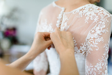 Beim Anziehen des Brautkleids vor der Hochzeit