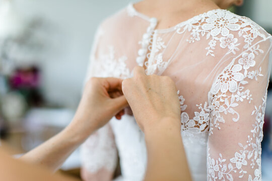 Beim Anziehen des Brautkleids vor der Hochzeit