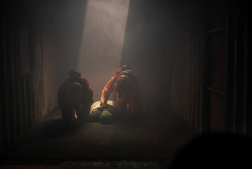 Two firefighters are working together to simulate a rescue scenario with the dummy models.