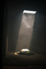 Vertical picture of dummy of a victim was illuminated light from above in the galvanized room.